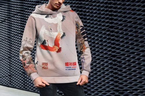 PSD mockup of an adult hoodie with intricate Japanese-style graphics, displayed outdoors with a textured background.