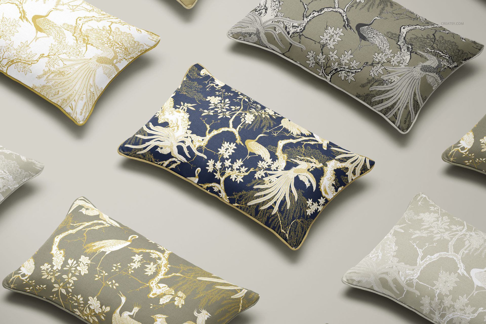 Multiple piped cushions with intricate gold and white bird and tree designs, arranged on a neutral background in a mockup.