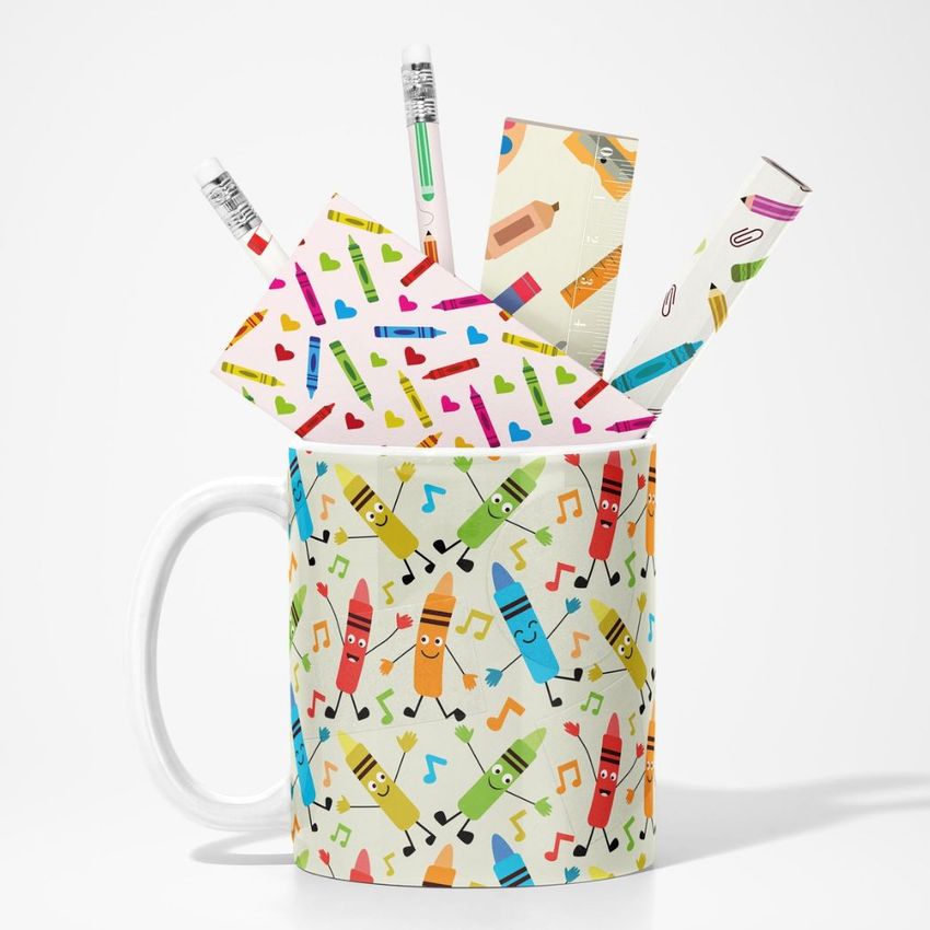 Mug mockup featuring a white mug with a colorful dancing crayon pattern, filled with stationery items decorated in similar designs.