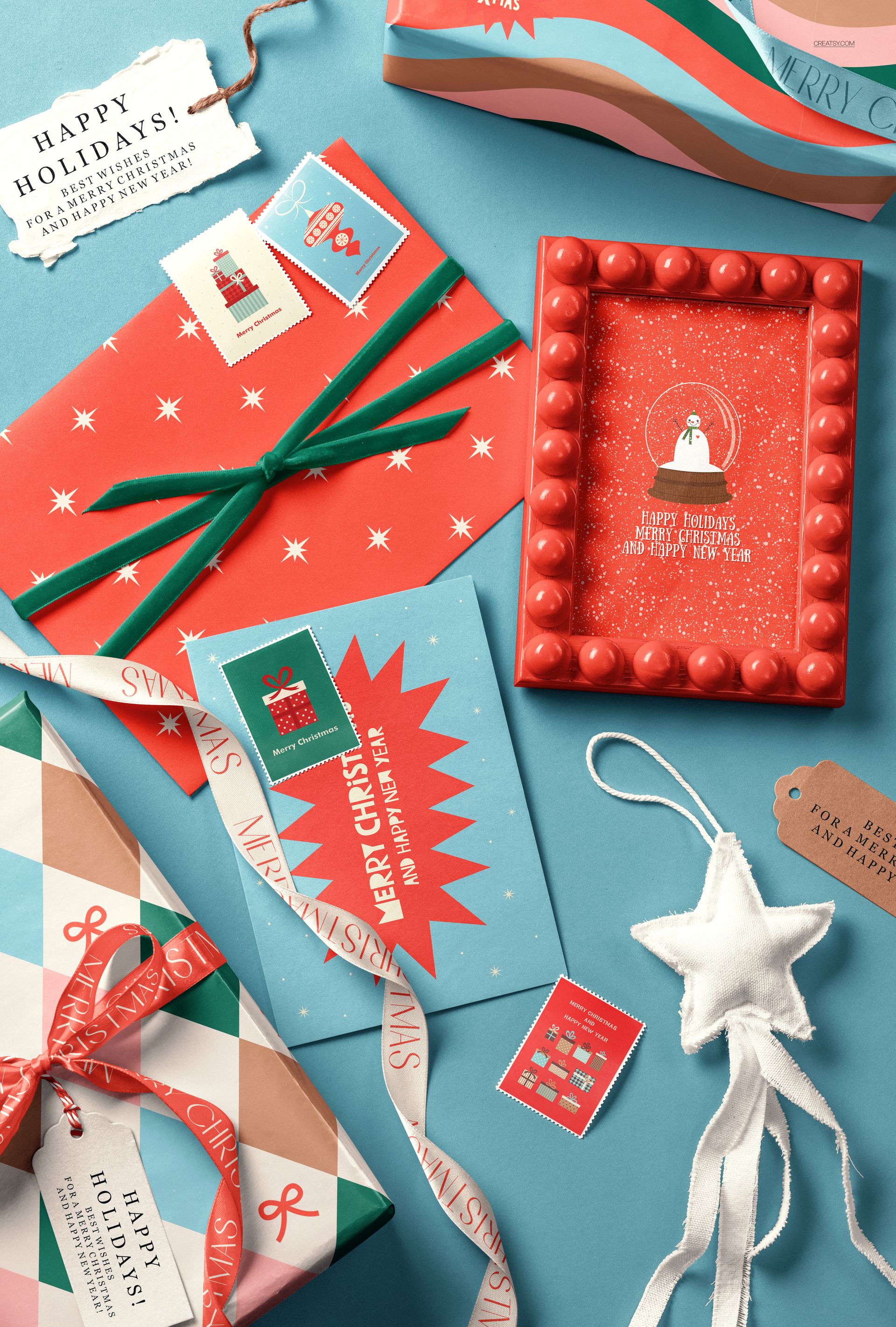 Christmas gift wrapping mockup featuring wrapped presents, greeting cards, and festive decorations on a blue surface.