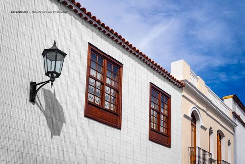 Old town street mural PSD mockup showing a building facade with grid pattern, wooden framed windows, and lamp.
