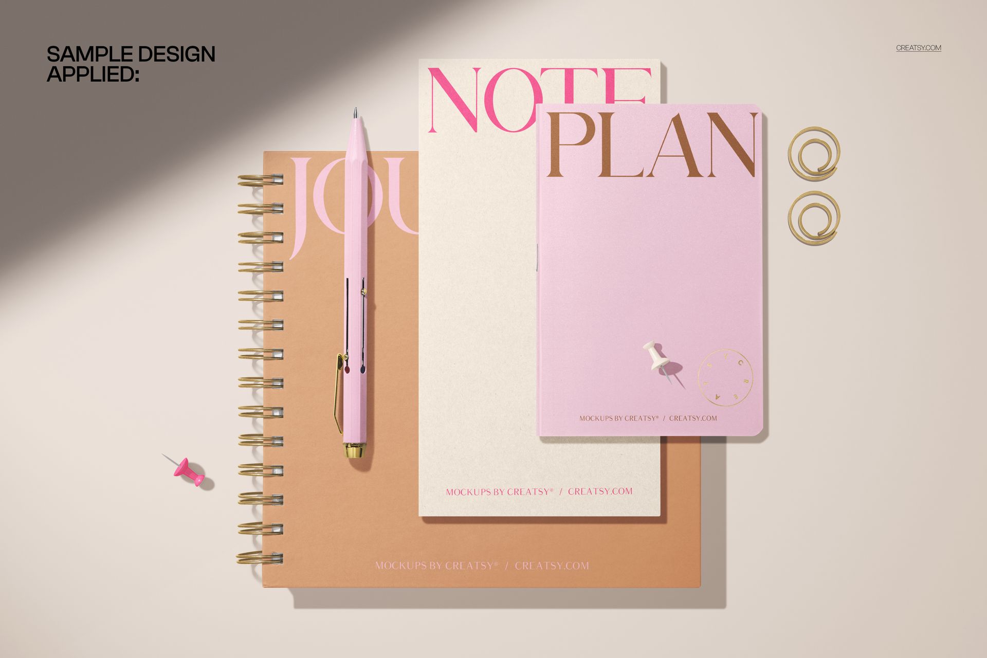 Stationery mockup featuring a spiral journal and softcover notebooks in beige and pink tones, viewed from above.