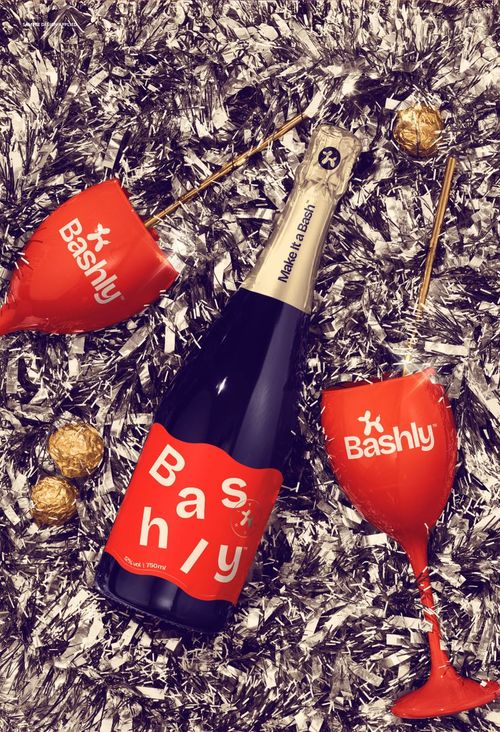 PSD mockup showing a champagne bottle and red glasses surrounded by metallic silver tinsel decorations.