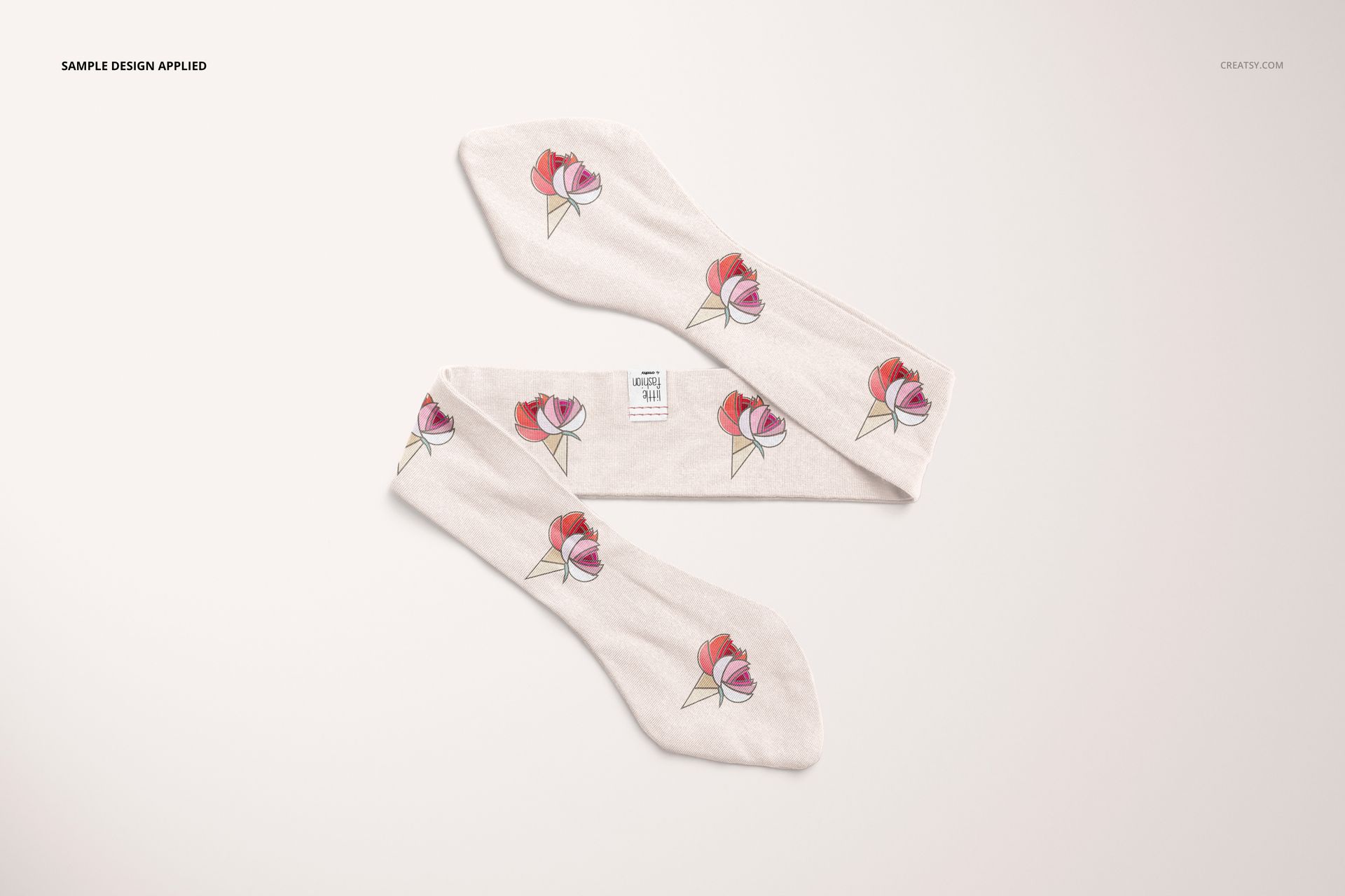 Top view of a swaddle set mockup featuring two white swaddle blankets with a floral ice cream cone pattern on a light background.