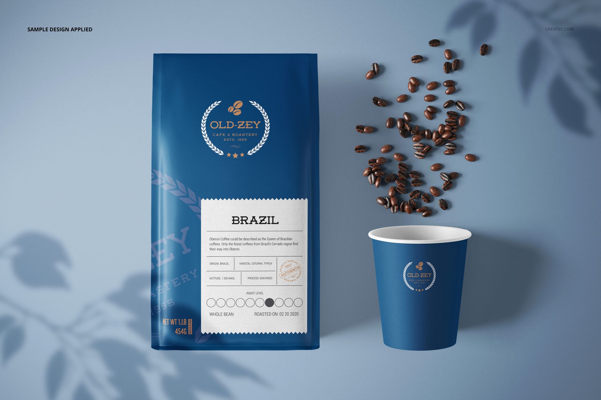 Paper coffee bag mockup and matching blue cup displayed on a blue background, with coffee beans accenting the scene.