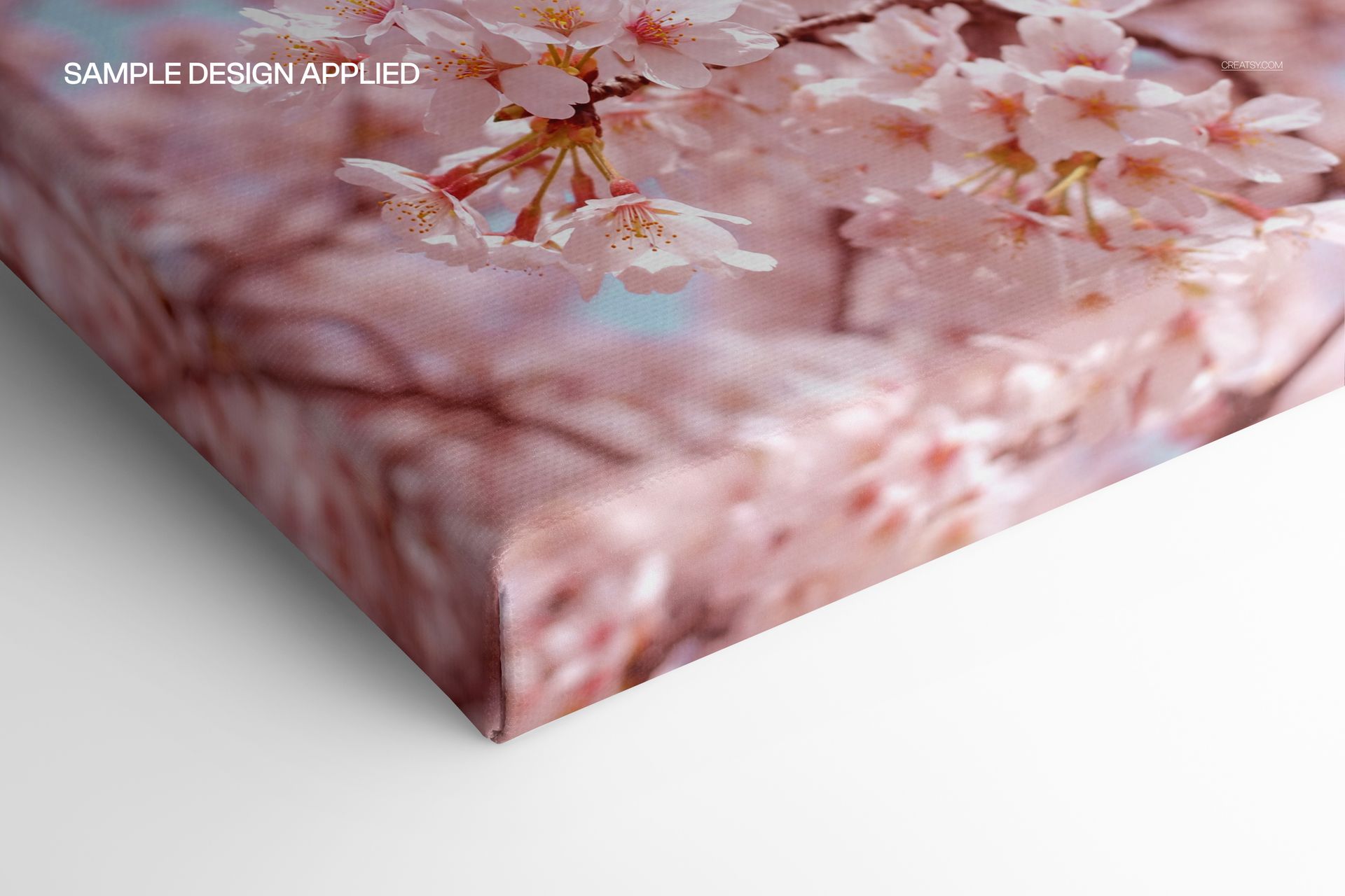 Detailed corner perspective of a premium cotton canvas mockup showing a floral print with soft pink blossoms.