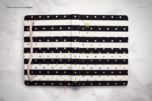 Top view of a planner mockup featuring alternating black and white stripes with gold hearts, lying open on a light background.