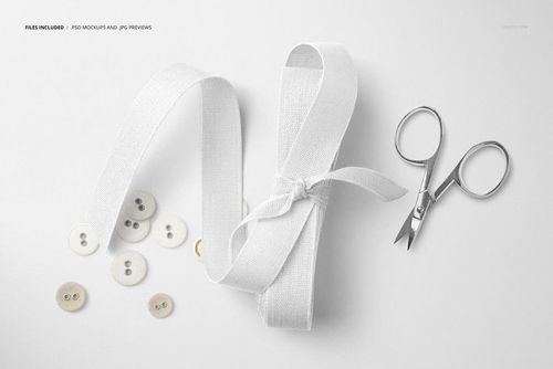 Mockup scene featuring a white cotton ribbon, metal scissors, and several buttons arranged on a clean, light backdrop.