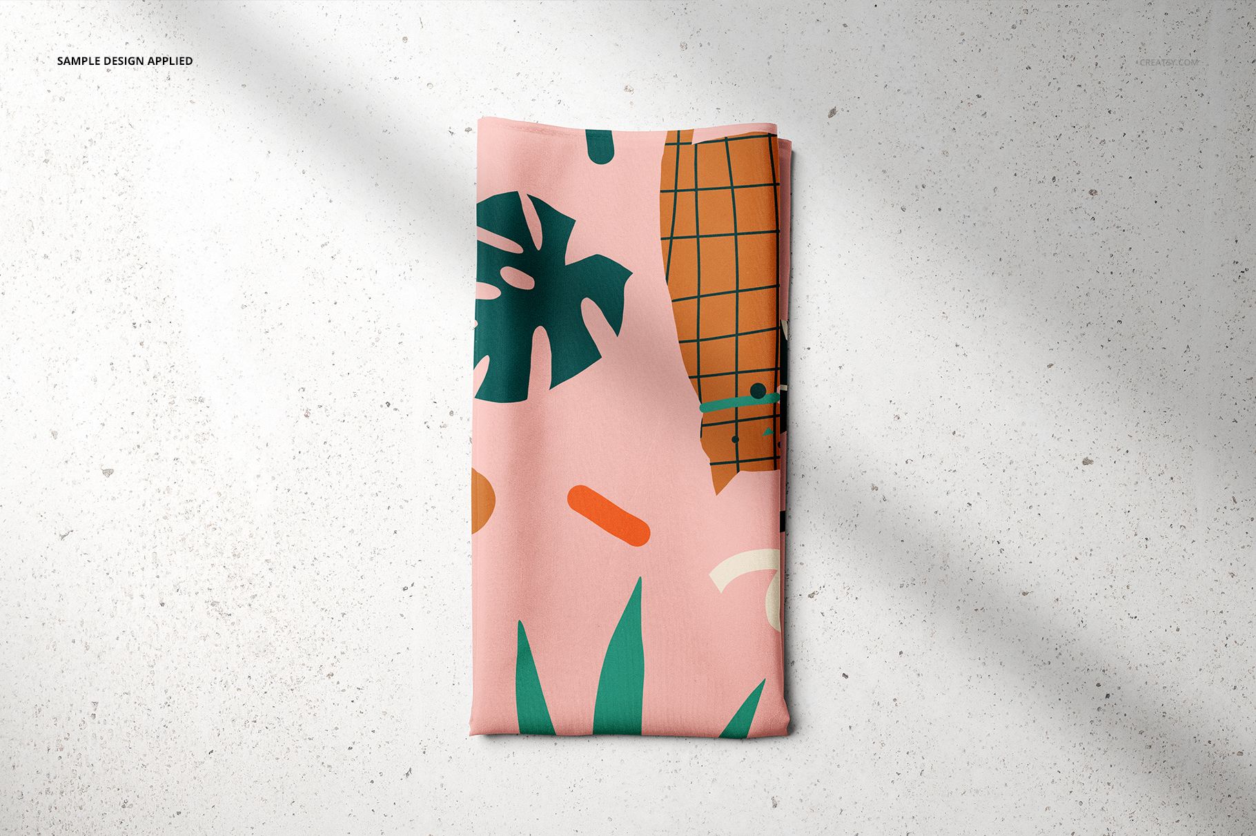 PSD mockup of a pet bandana displaying a modern pattern with green foliage and orange accents, laid flat on a light background.