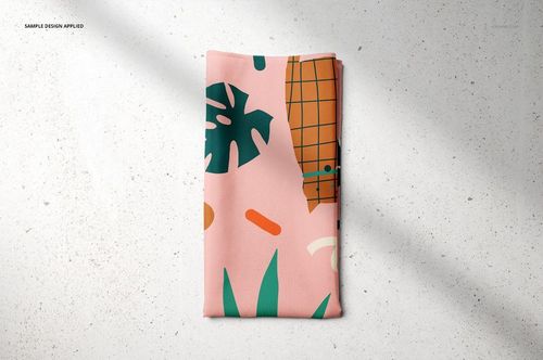 PSD mockup of a pet bandana displaying a modern pattern with green foliage and orange accents, laid flat on a light background.