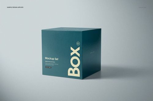 Teal glossy square box mockup with large white lettering, displayed in a studio setting with soft shadows.