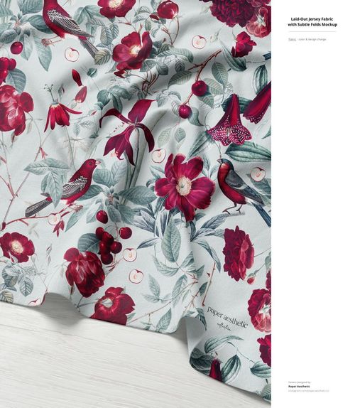 Jersey fabric mockup with red flowers and birds on a light background, displayed flat with natural draping and shadows.