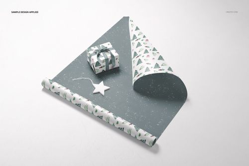 Gift wrapping paper mockup featuring a partially unrolled sheet with festive tree patterns, a wrapped box, and a star ornament on a light surface.