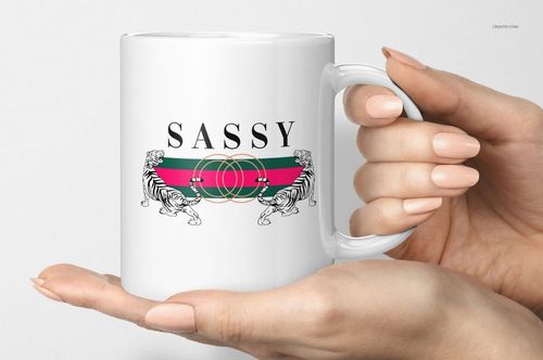 White 11oz mug with a bold 'SASSY' text and two illustrated tigers facing each other, held in a hand, front view.