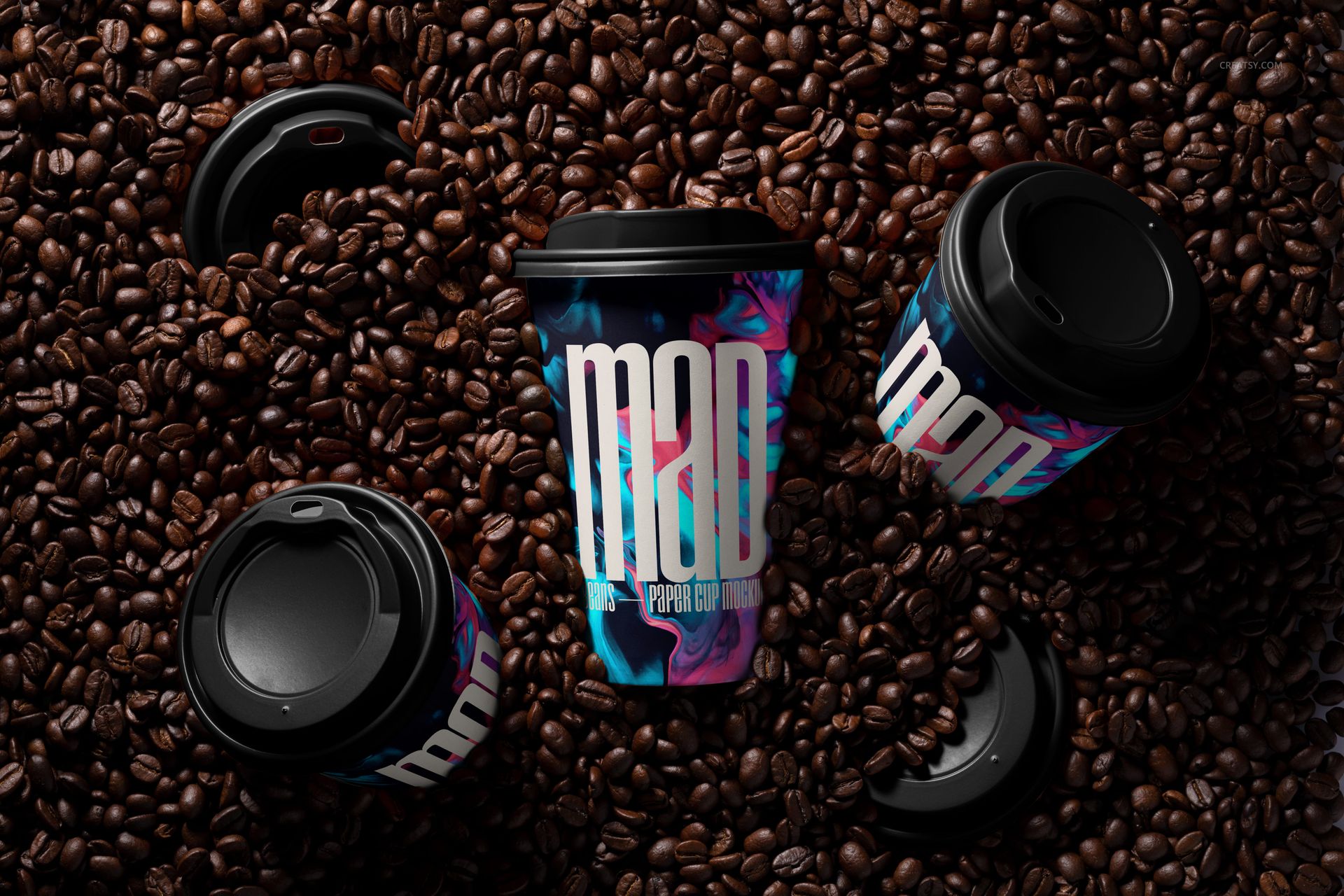 PSD mockup of paper cups with vibrant patterns and black lids surrounded by coffee beans, top perspective.