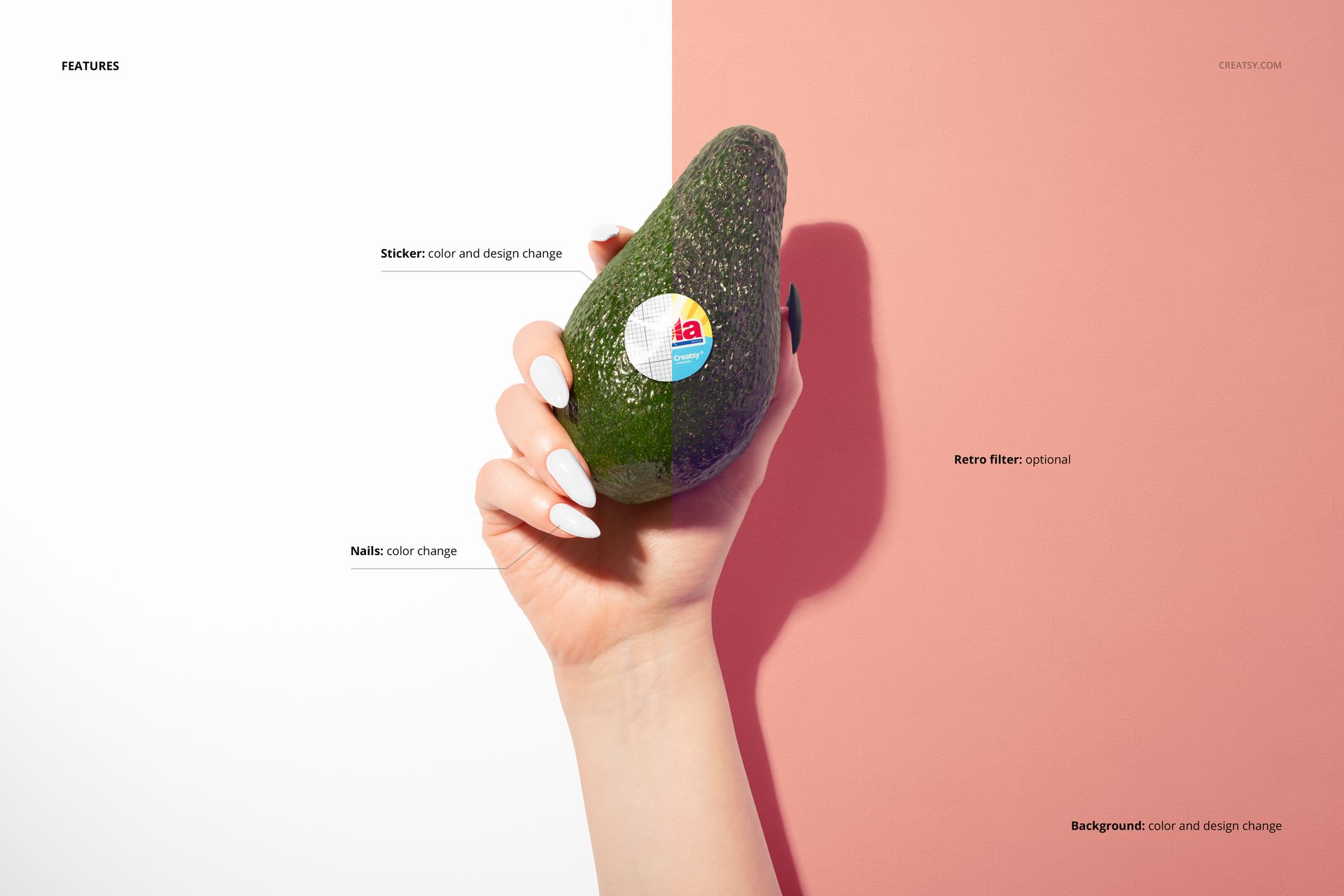 Hand holding a whole avocado with a round sticker on its surface, set against a split pink and white background.
