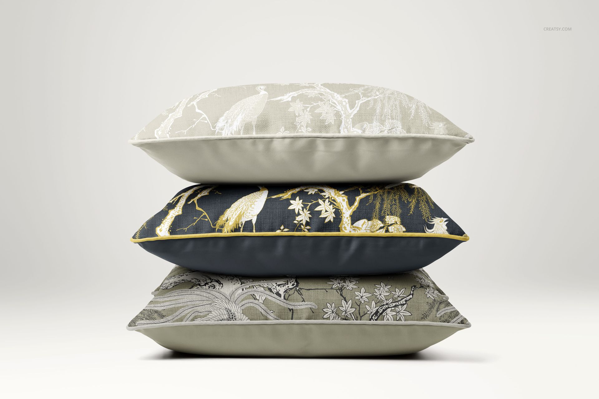 Stack of three reversible piped cushions with nature-inspired patterns, shown in a front view on a neutral background.