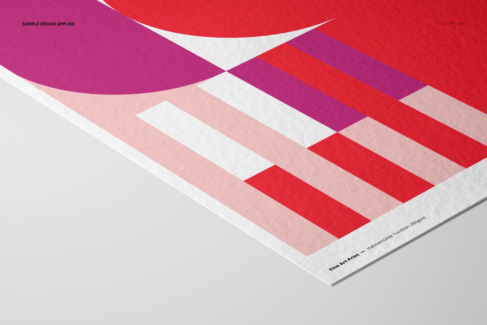 A3 fine art print mockup featuring a geometric abstract design in red, pink, and white, angled on a light surface.