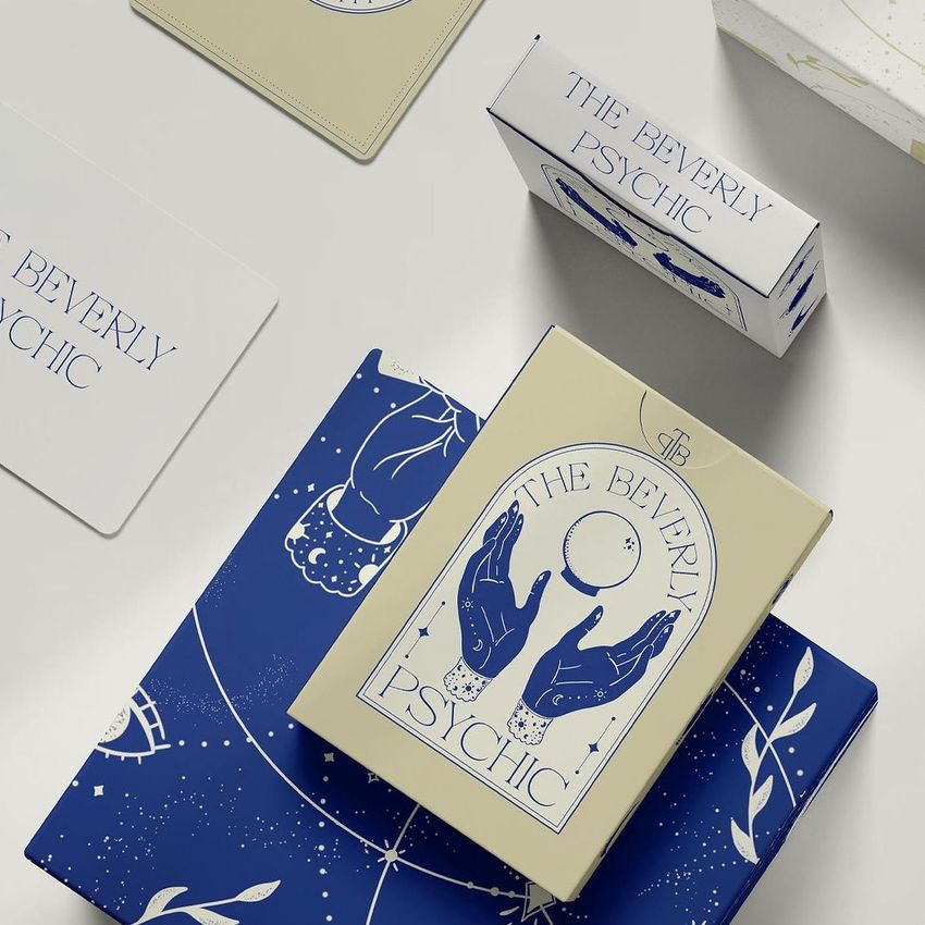 Playing cards mockup set featuring a tarot-inspired box design with blue and cream colors, celestial graphics, and elegant text.