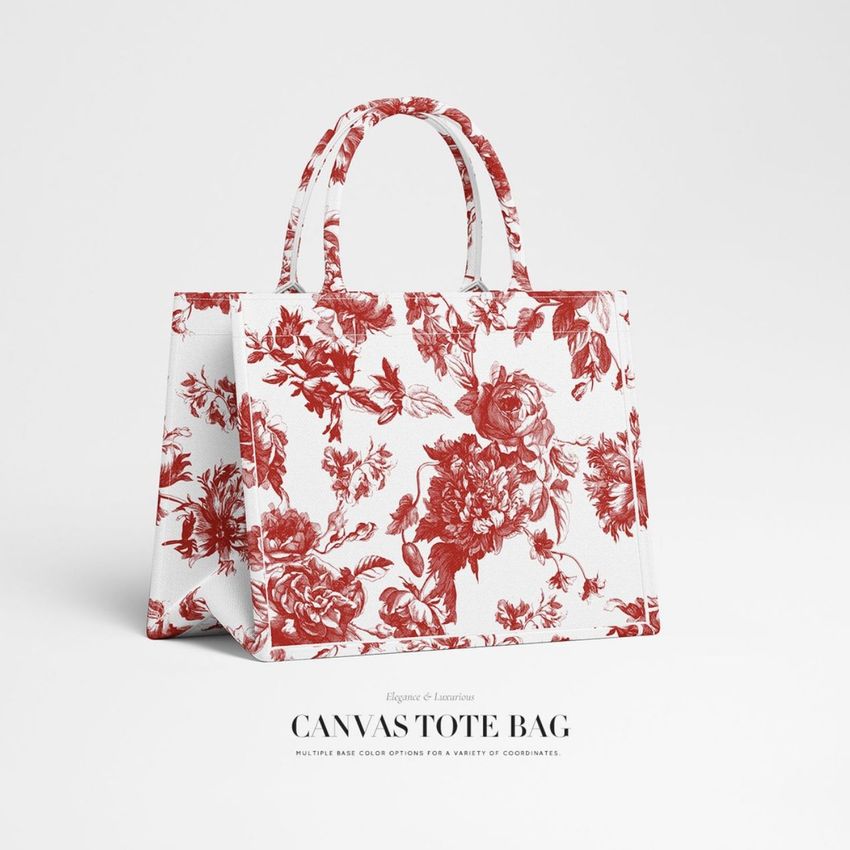 Canvas tote bag mockup featuring a red floral pattern on white fabric, displayed upright on a plain light background.