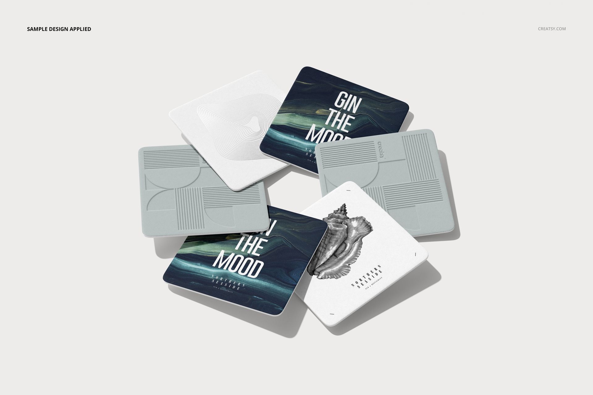 PSD mockup showing square drink coasters with different artistic designs and minimalist color tones.