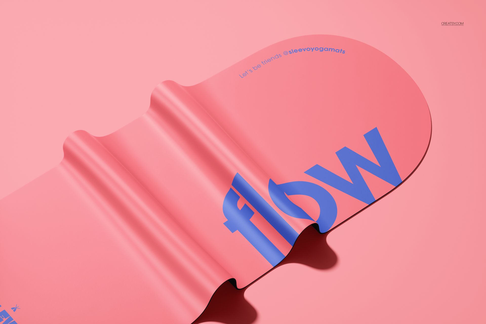 Oval yoga mat mockup in pink with blue text, shown from a top angle on a solid pink background with gentle folds.