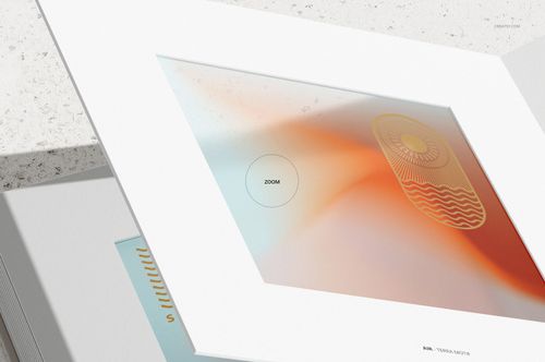 Open artbook mockup with a white frame, displaying abstract artwork in soft orange and blue tones on textured pages.