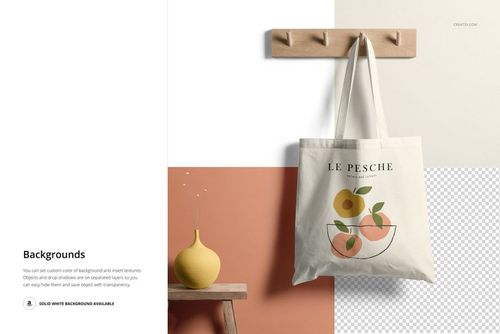 Front view of a tote bag mockup hanging on a wooden wall hook, featuring a minimalist fruit design and neutral background.