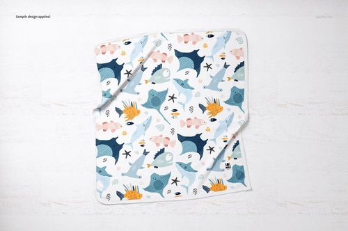 Square cotton baby blanket mockup featuring playful marine creatures in blue, orange, and pink, viewed from above.