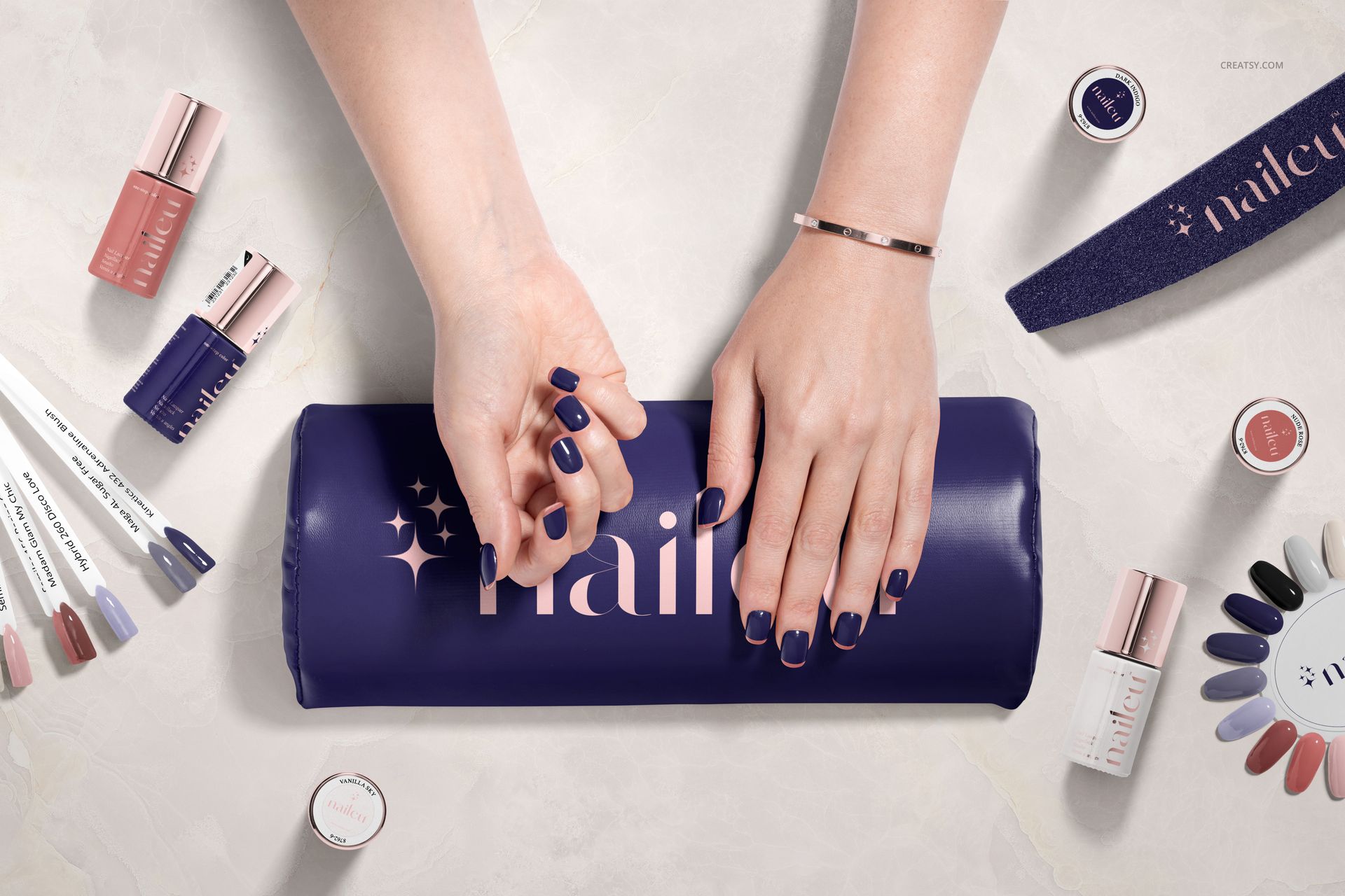 Hybrid nail polish PSD mockup featuring hands with painted nails, manicure accessories, and an assortment of polish shades.
