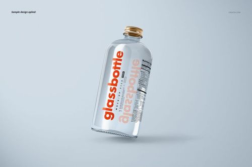 Glass bottle mockup shown at a tilted angle, transparent with water inside, orange text label, gold screw cap.
