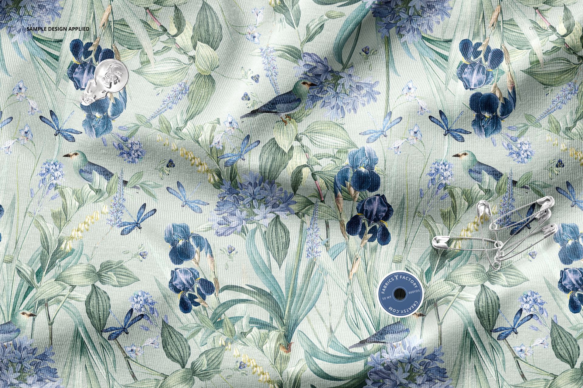 Top view of a wrinkled textile mockup with detailed floral and bird motifs on a light background.