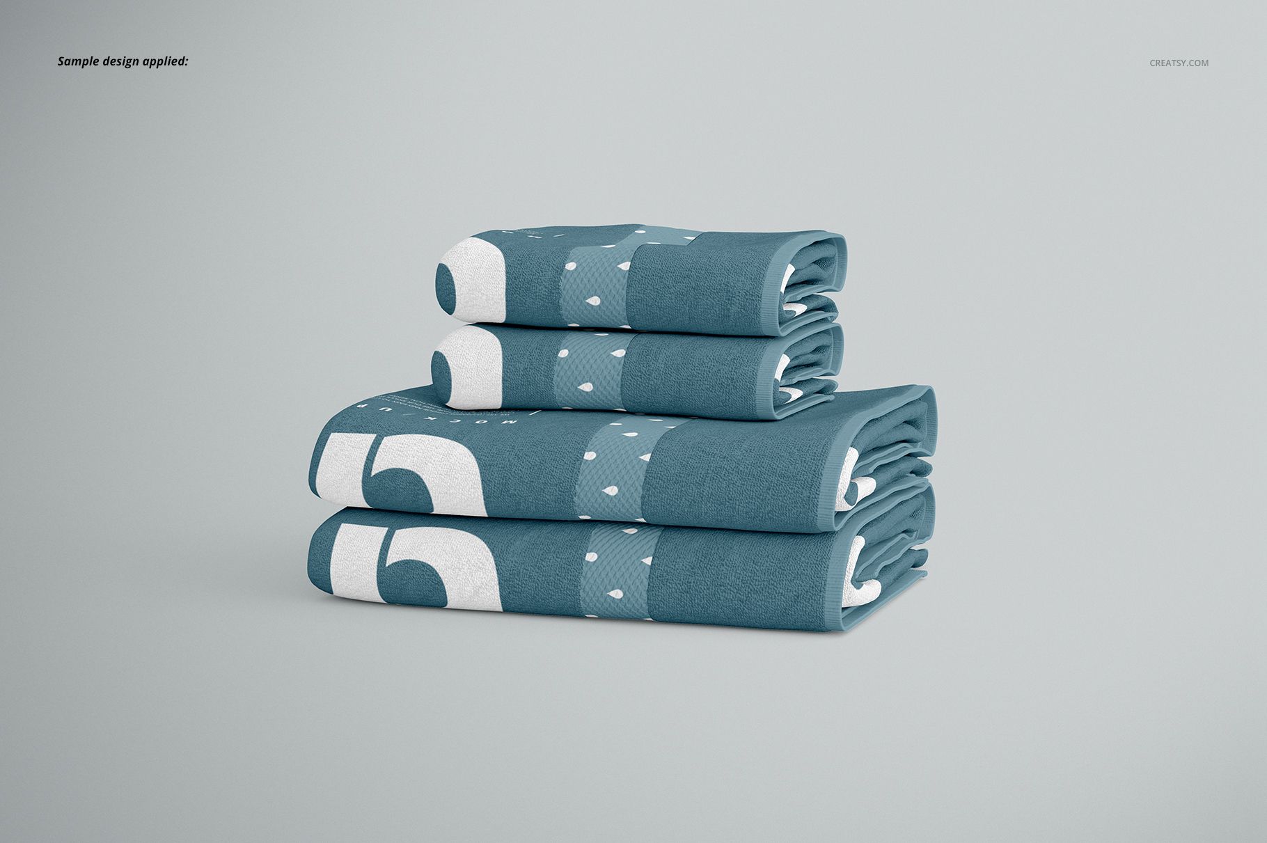 Bath towel PSD mockup set showing a neat stack of blue towels with bold white shapes, arranged on a plain background.