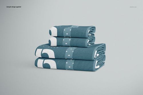 Bath towel PSD mockup set showing a neat stack of blue towels with bold white shapes, arranged on a plain background.