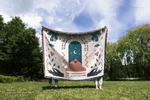 PSD mockup of an 80x60 jacquard throw blanket with decorative artwork, displayed outside on a sunny day.