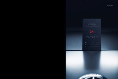 Dark automotive business card mockup standing upright on a reflective surface, front view with minimal lighting.