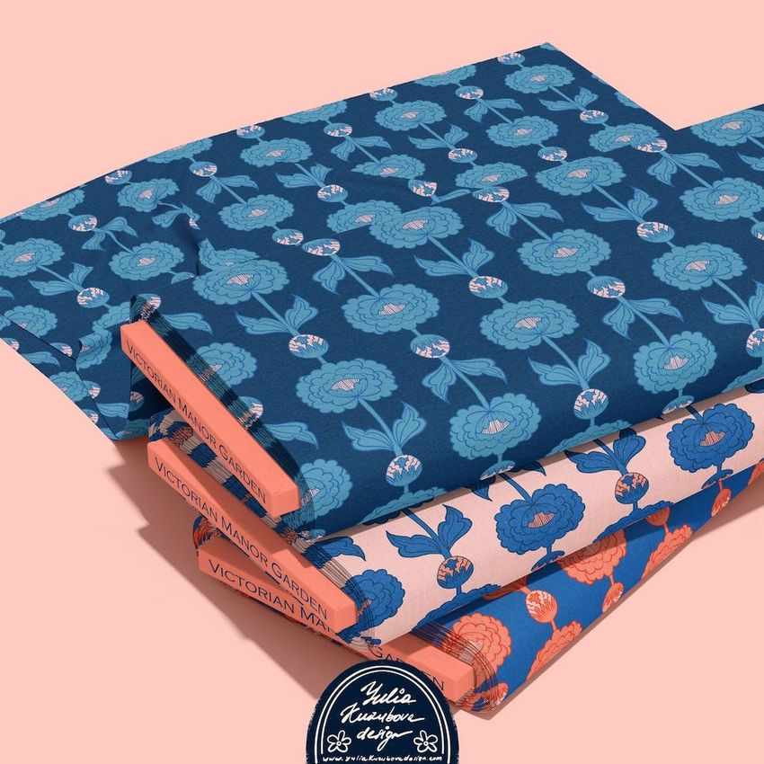 Fabric bolts mockup featuring three stacked bolts with floral patterns in blue, teal, and coral on a pale pink background.