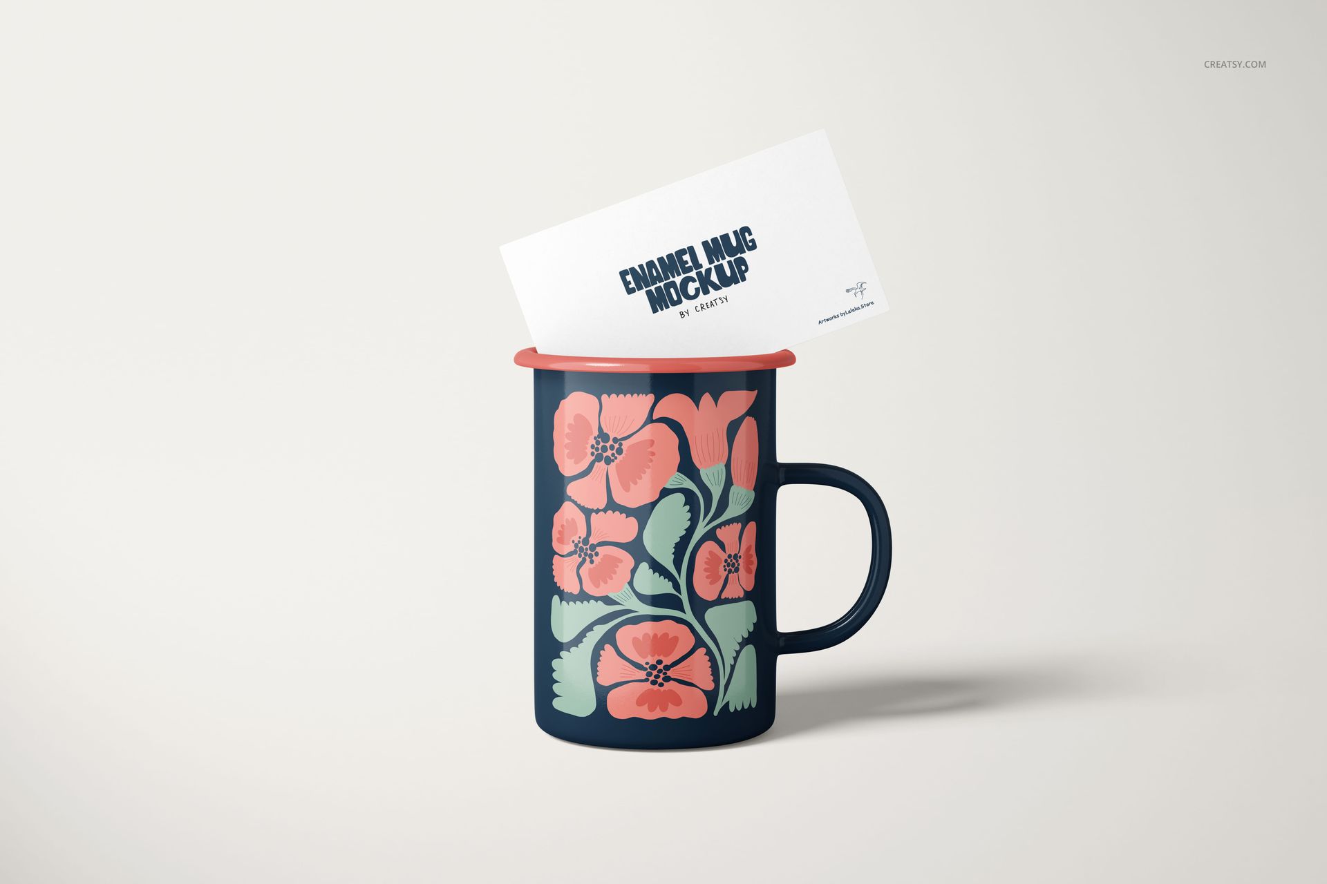 Front view of a 450ml enamel mug mockup featuring pink and green flowers, with a card placed inside the mug.