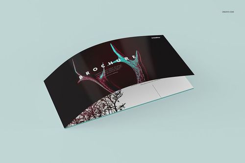 Curved brochure mockup displayed on a light blue surface, featuring a dark cover with abstract graphics and text.