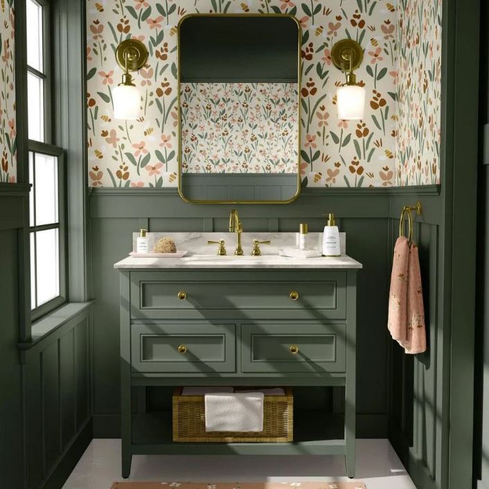 Bathroom mockup showing a green vanity with gold fixtures, floral wallpaper, and a rectangular mirror with wall sconces.