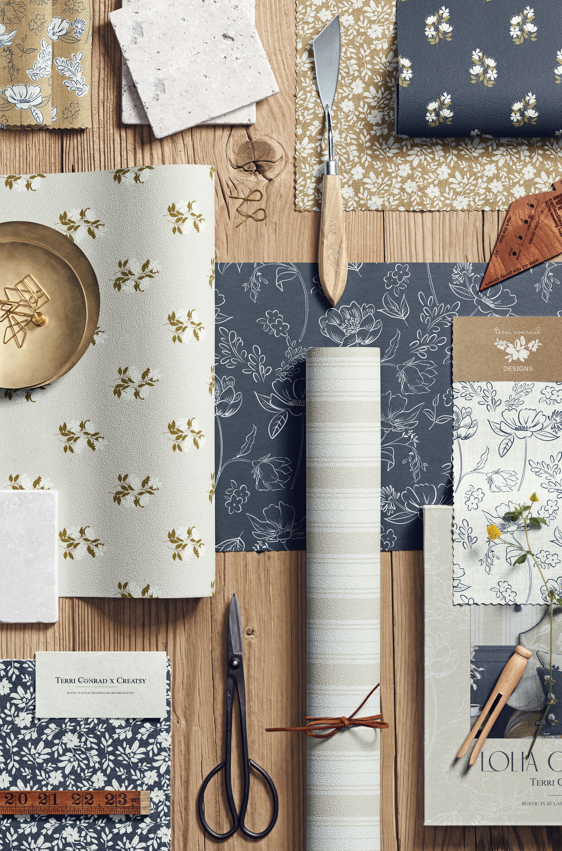 Overhead perspective of a moodboard mockup with floral fabrics, craft supplies, and decorative objects on wood.