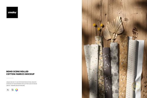 PSD mockup showing rolled cotton fabrics in earthy tones and floral prints, styled with dried plants on wood.