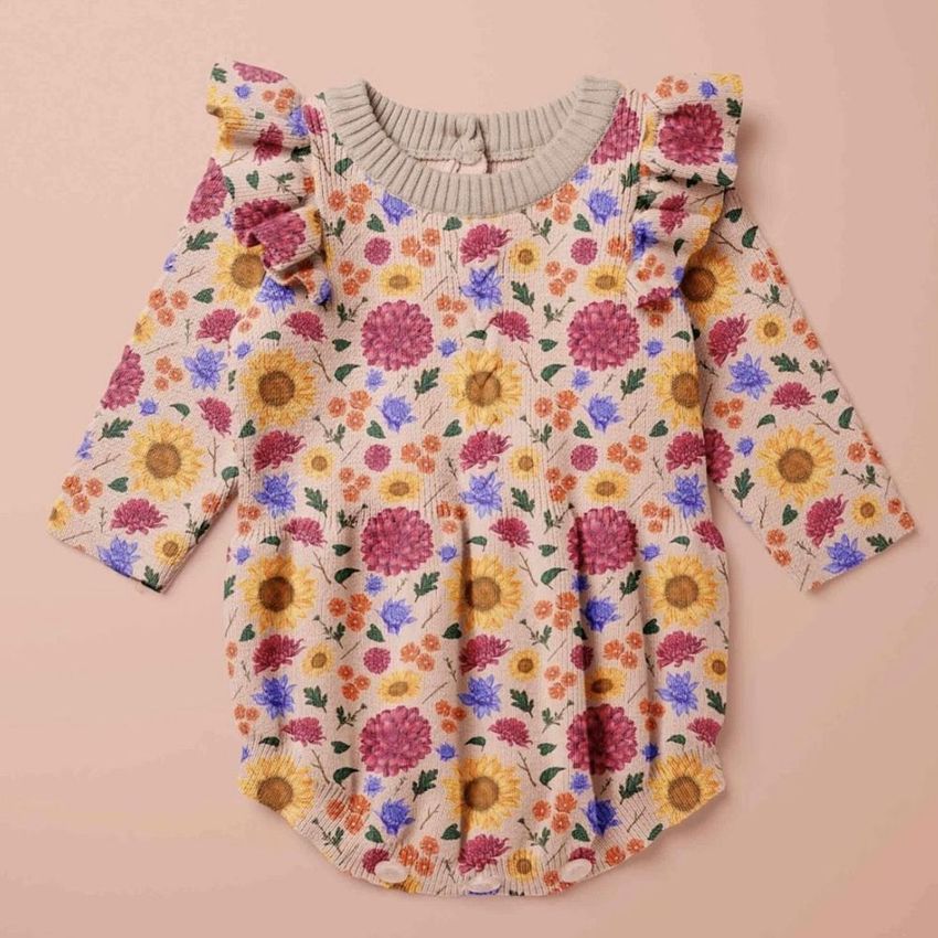 Knitted romper mockup featuring a floral pattern with pink, yellow, and purple flowers on a light beige background, displayed flat.