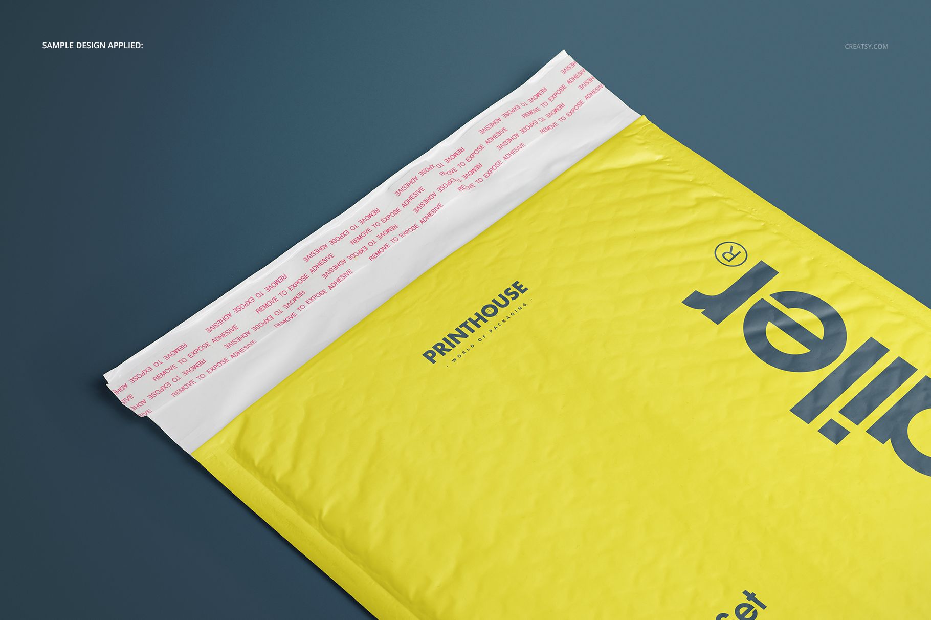 Yellow bubble mailer envelope mockup with printed text, shown from a top angle on a dark blue surface.