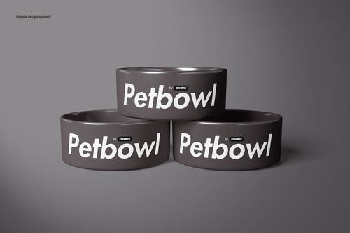 PSD mockup showing a trio of dark gray pet bowls with prominent white text, displayed in a studio-style setting.