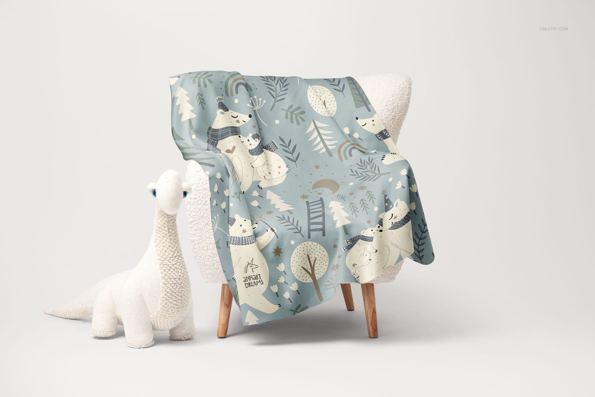 Fleece blanket with rounded corners draped over a sherpa chair, featuring a playful polar bear pattern in soft blue tones.