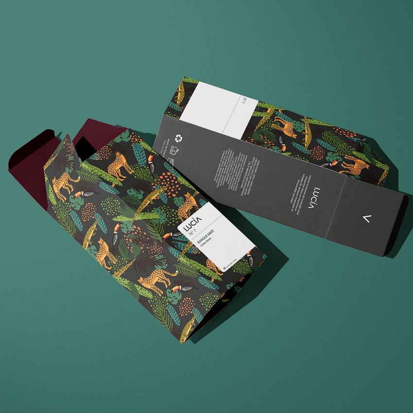 Tall box mockup featuring two rectangular boxes with jungle-themed patterns, one open and one closed, on a green background.