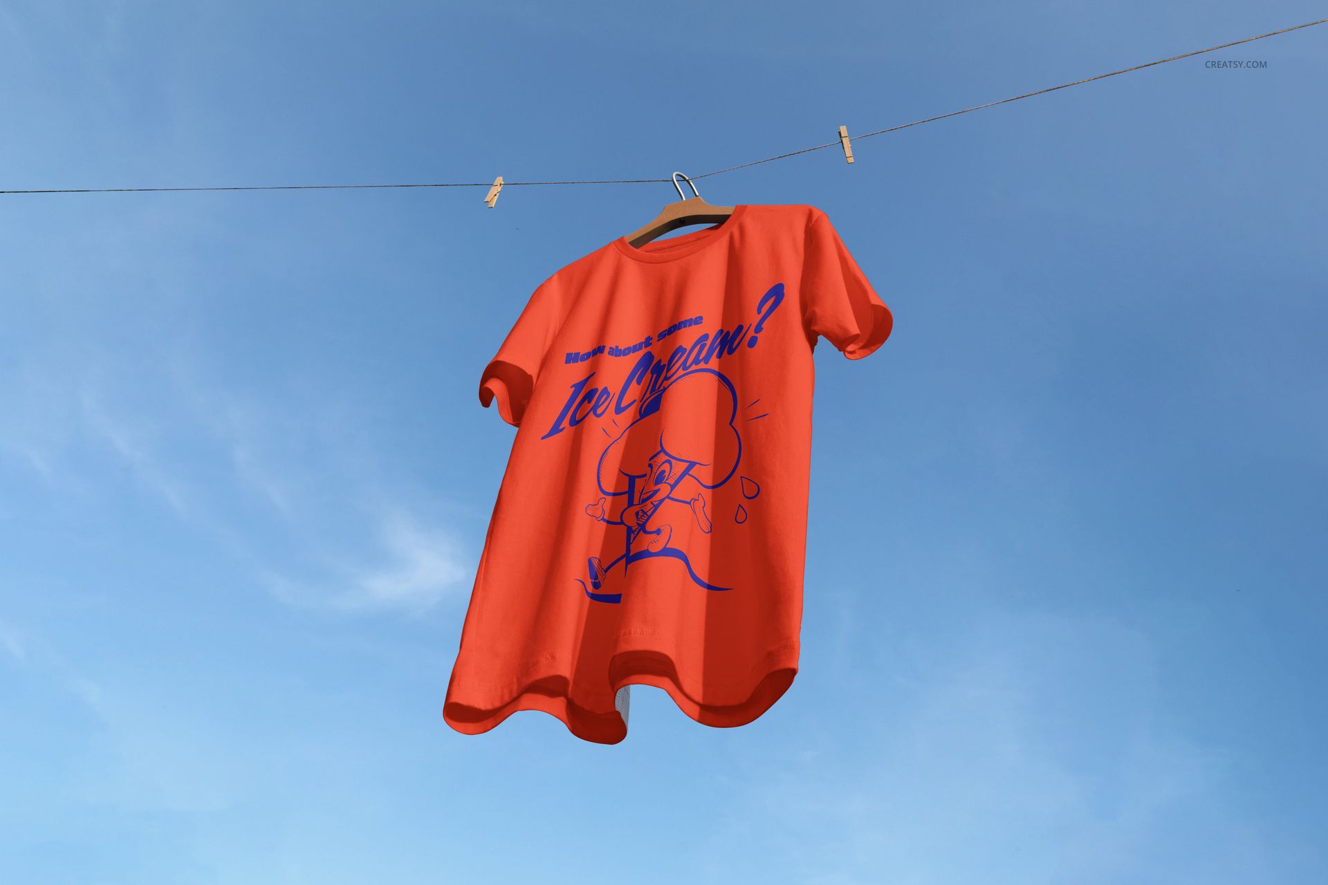 Red adult t-shirt mockup hanging on a clothesline against a clear blue sky, viewed from the front.