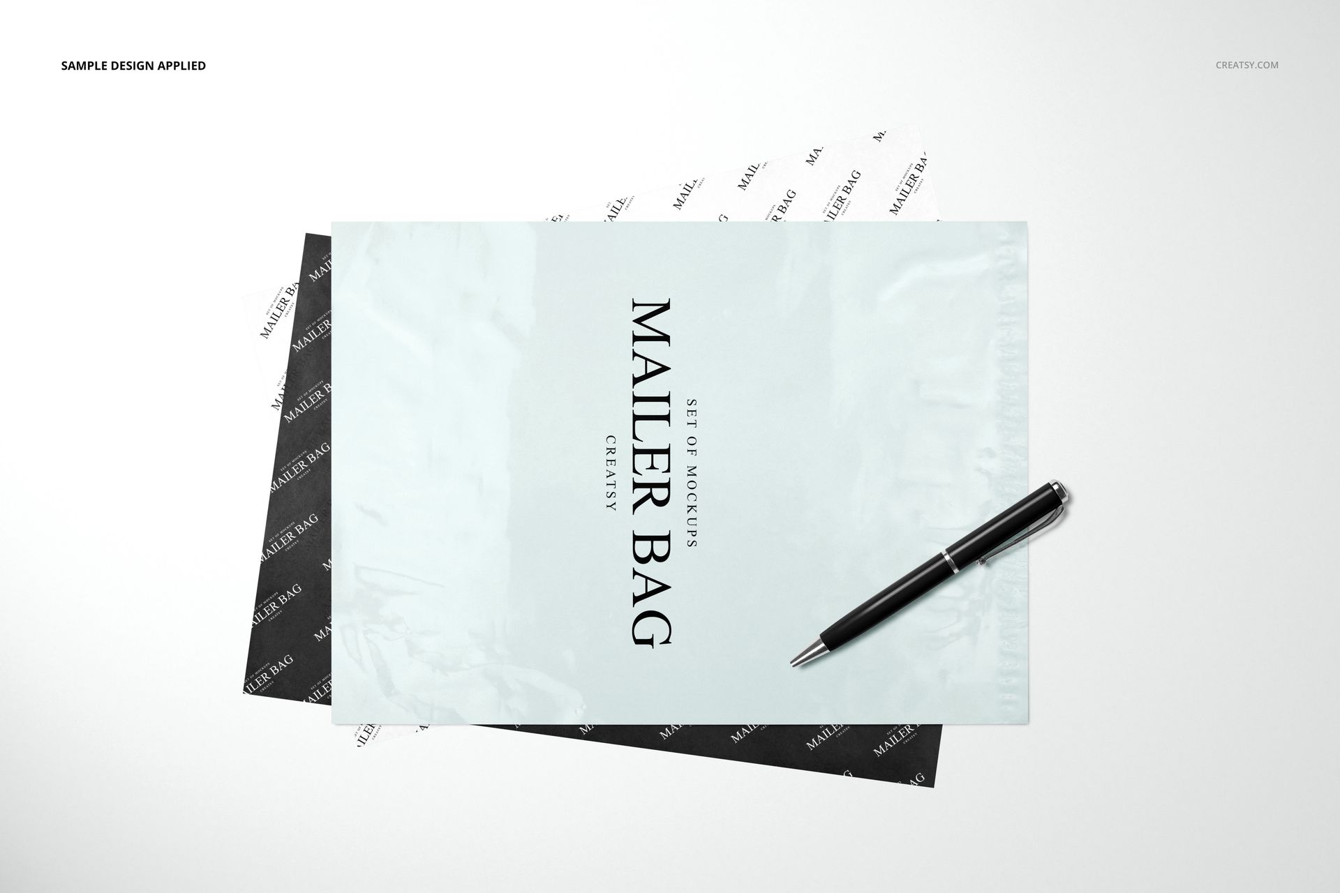 Front view of a mailer bag and wrapping tissue paper mockup set with monochrome designs, pen placed on top.