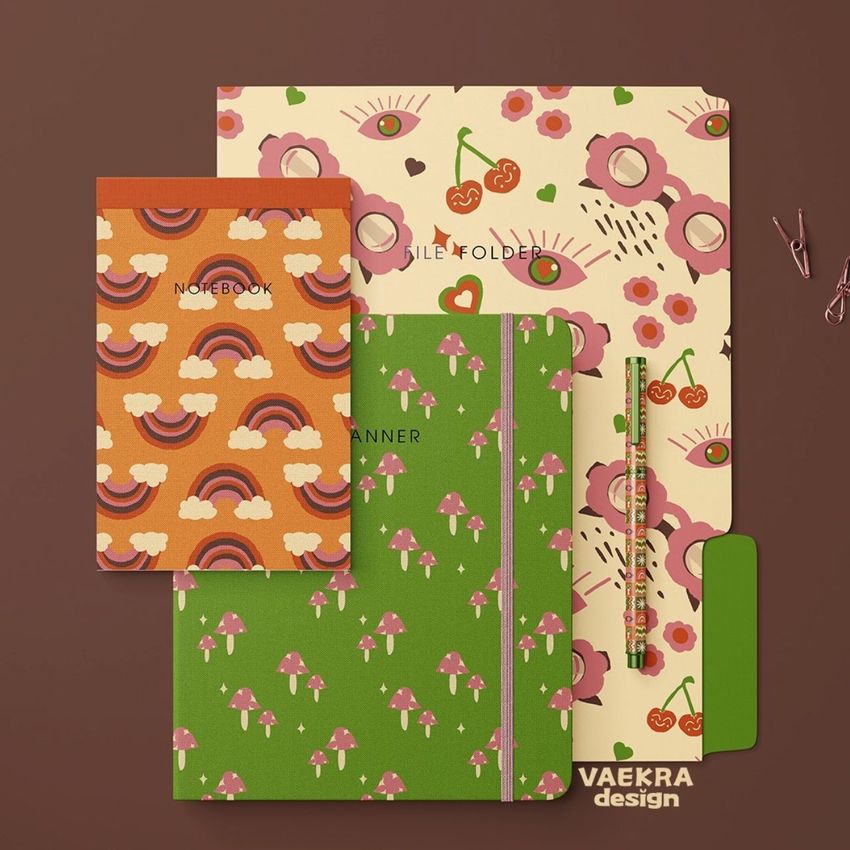 Stationery mockup featuring a notebook, planner, file folder, and pencil with retro patterns of rainbows, mushrooms, and cherries on a brown background.